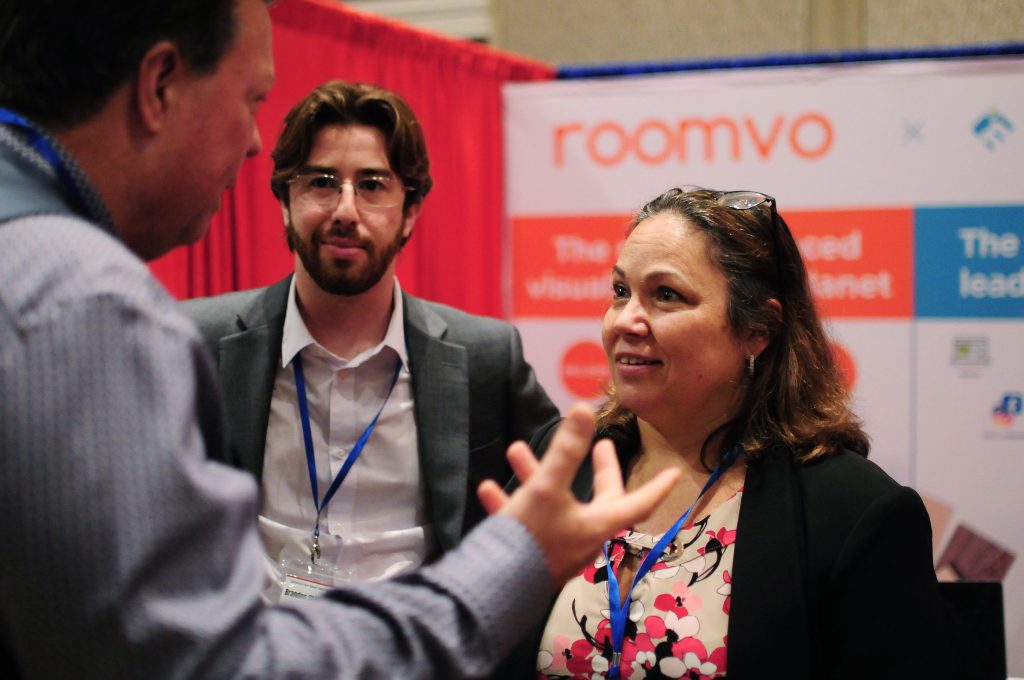 people meeting and talking with convention in background